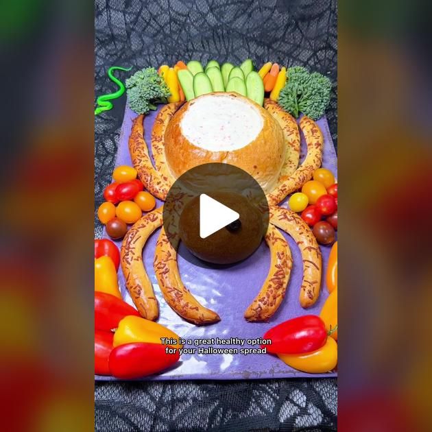 a crab made out of fruits and vegetables on a purple platter with a video