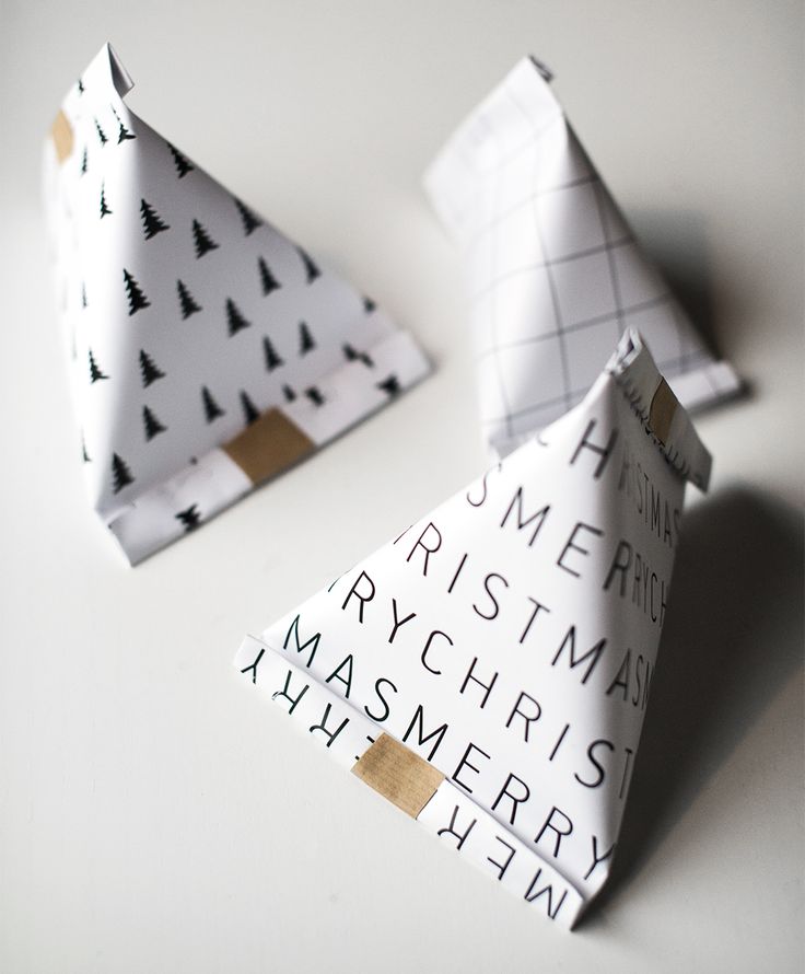 two folded paper christmas trees sitting on top of a white table next to each other