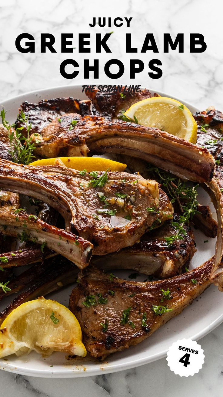 juicy greek lamb chops with lemon wedges and herbs on a white platter