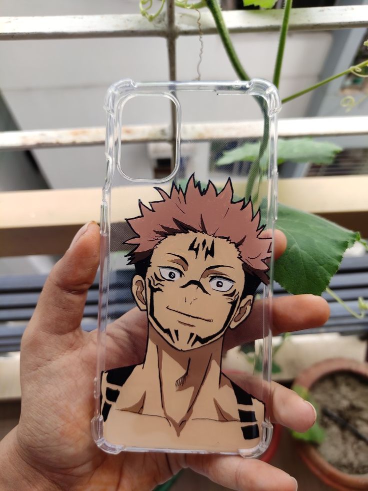 a person holding up a phone case with an anime character on it