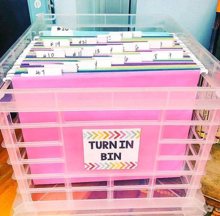 a pink plastic bin filled with lots of files