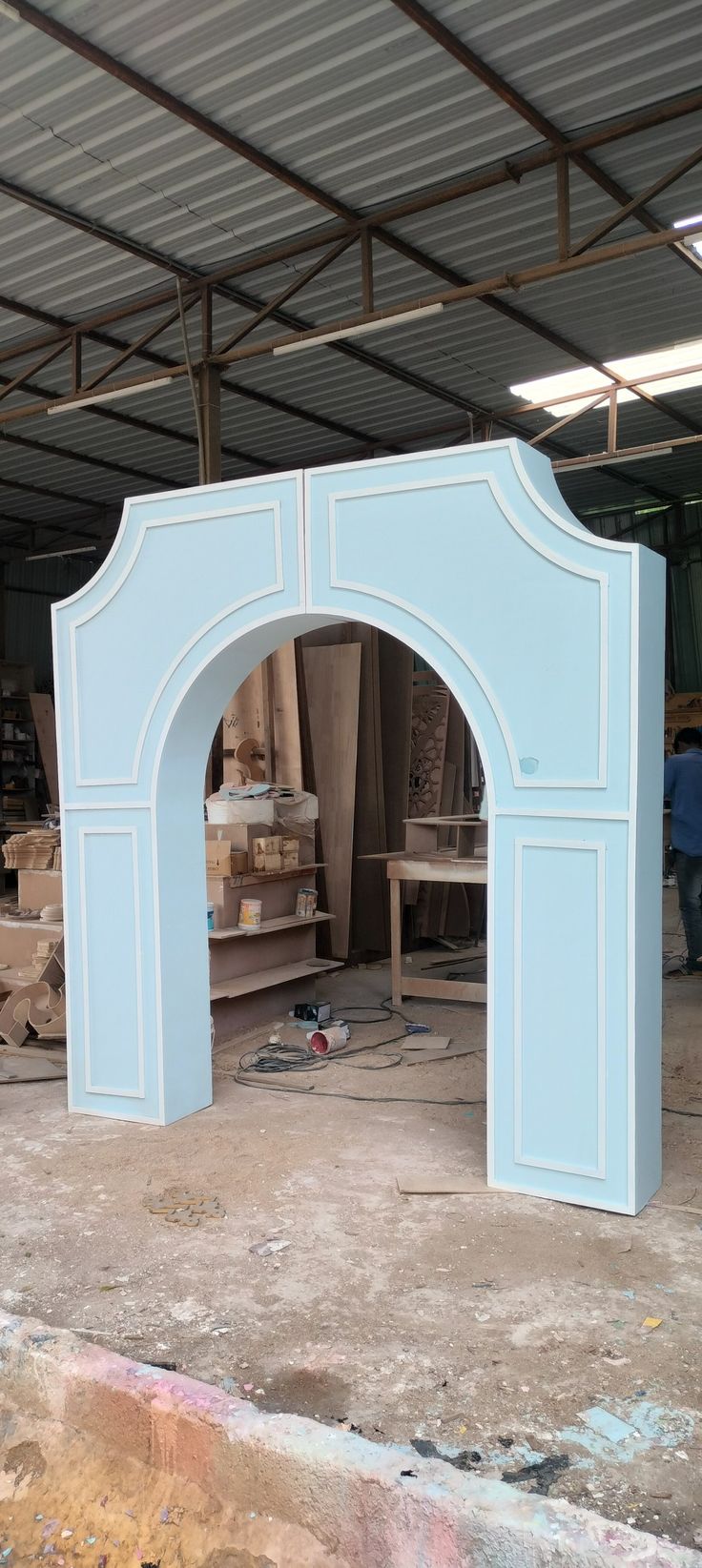 a large blue arch in the middle of a room filled with boxes and other items