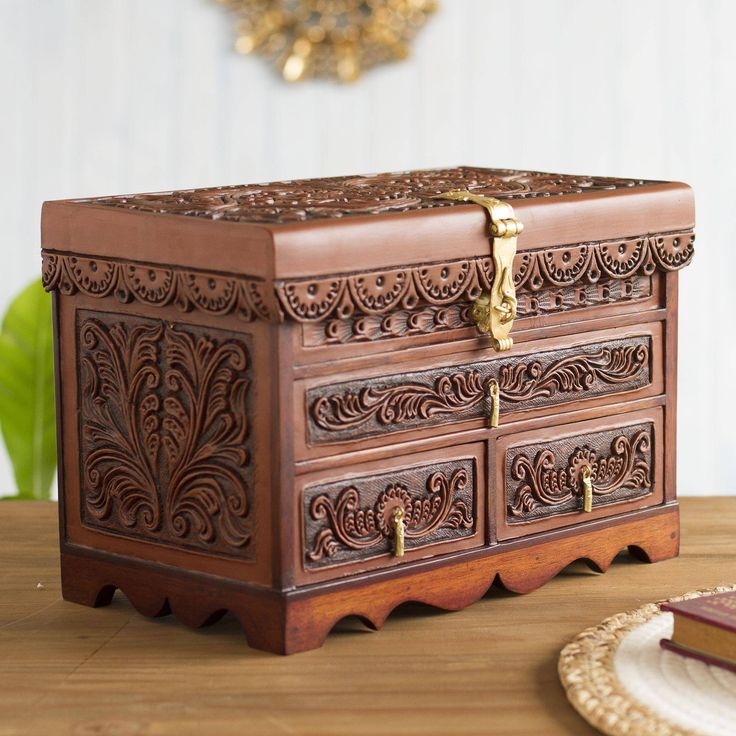 an ornate wooden box sitting on top of a table next to a plate and fork