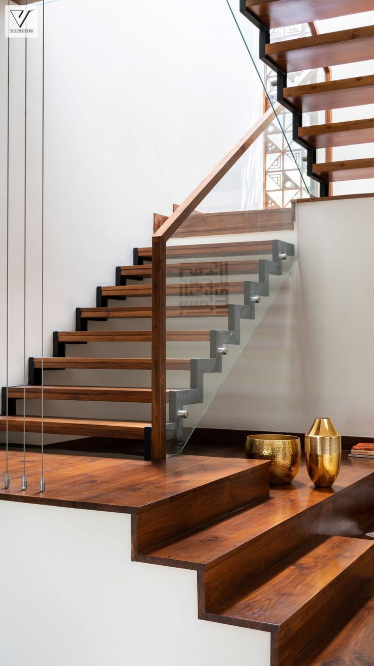 a stair case with glass railing and wooden handrails in a modern style home