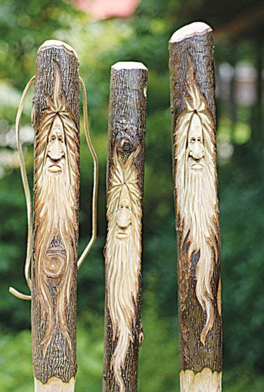 three carved wooden poles with faces on them