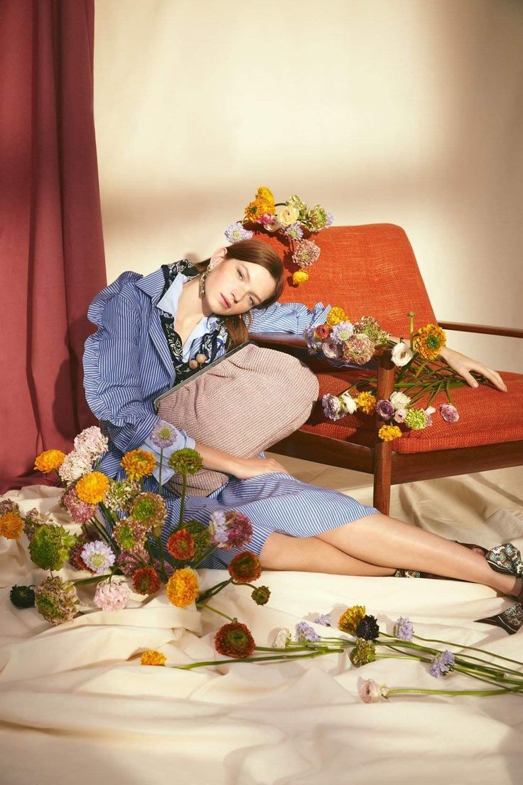 a woman sitting on a chair with flowers in her hair