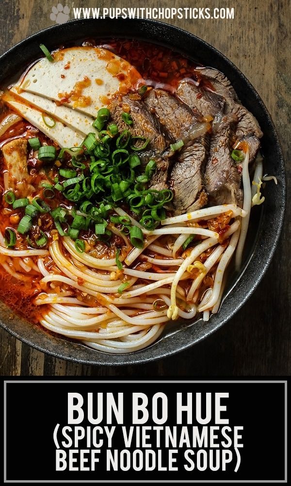 a bowl filled with noodles and meat on top of a wooden table