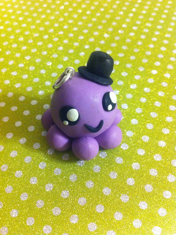 a purple octopus with a top hat on it's head sitting on a polka dot table