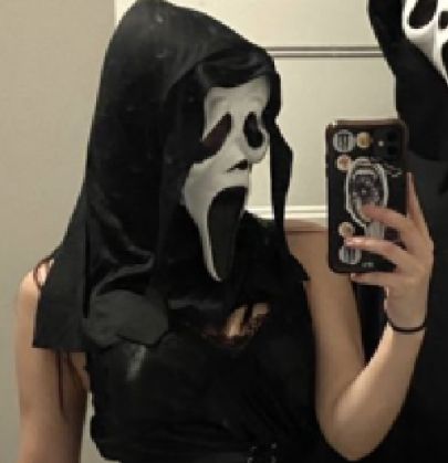 a woman wearing a mask taking a selfie with her cell phone