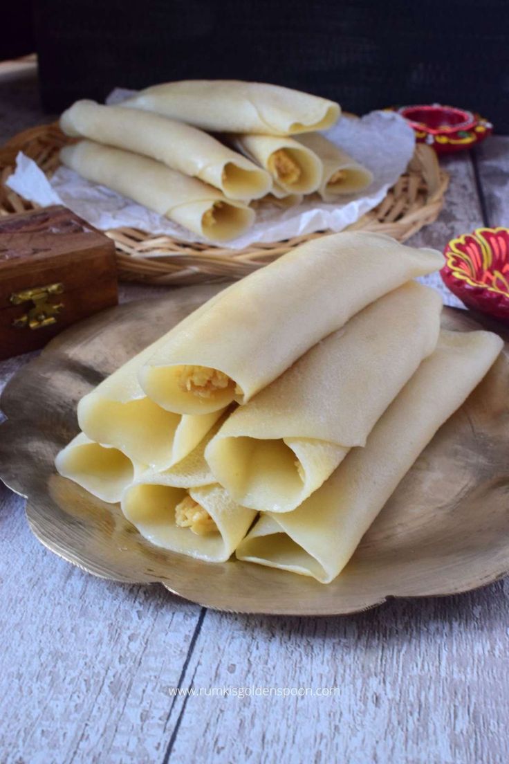 some dumplings are on a silver plate and next to other food items in wicker baskets