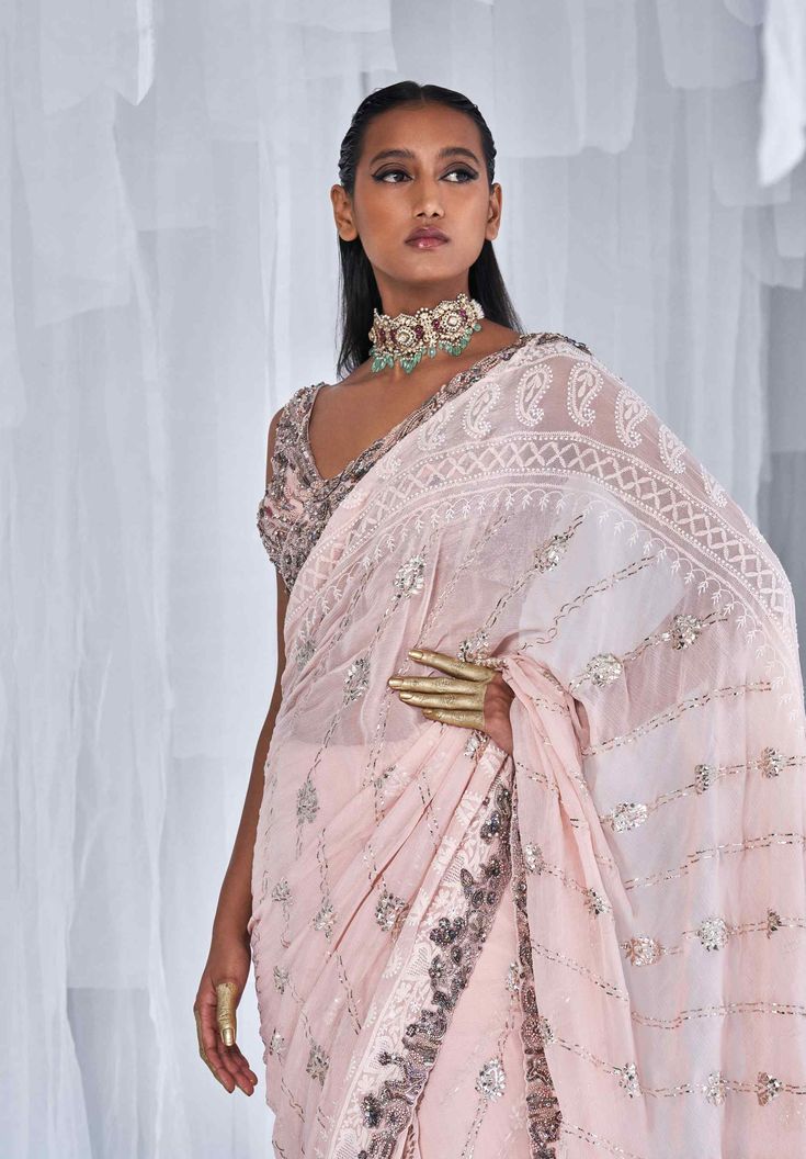 Editor's Note This set features a pale pink kamdani chikankari sari with a beautifully crafted zardozi border paired with an embroidered blouse. The delicate work on the sari and blouse make it a perfect choice for a sophisticated and elegant look. Fabric: Chiffon Color: Pink Components: Sari and blouse Occasion: Engagement Disclaimer: Product color may slightly vary due to photographic lighting sources or your monitor setting. Care: Dry Clean Only About the Designer Dolly J is an Indian occasio Chikankari Sari, Zardozi Border, Dolly J, Snow Rose, Chikankari Saree, Blouse Yoke, Wedding Service, Blouse Online, Bride Bridal