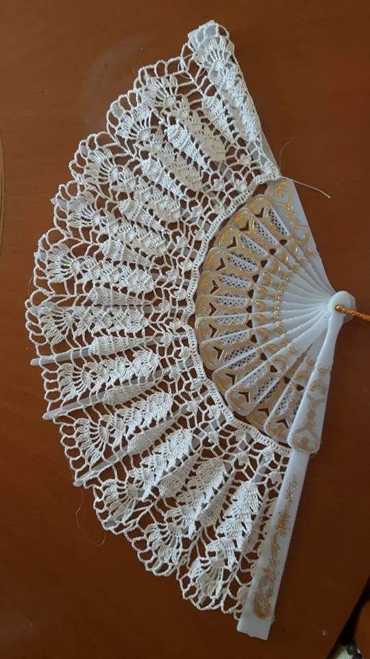 an umbrella made out of doily sitting on top of a wooden table next to a pair of scissors