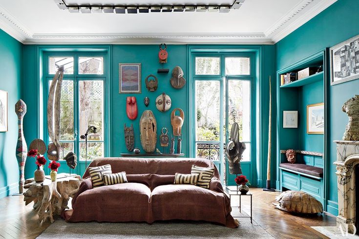 a living room filled with lots of furniture and decor on top of wooden flooring