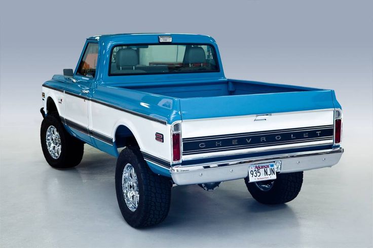 a blue and white pickup truck parked in a garage