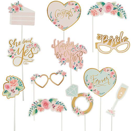 wedding photo booth props with flowers and hearts on them, including cake toppers for the bride and groom