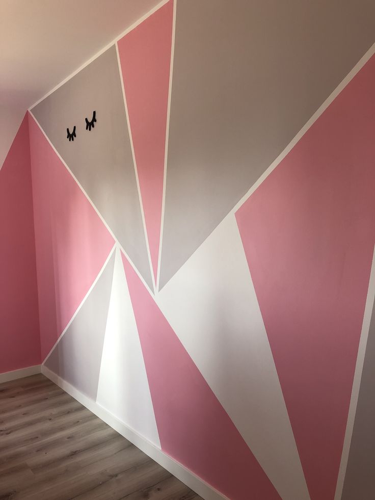 an empty room painted in pink and white with two butterflies on the wall next to it