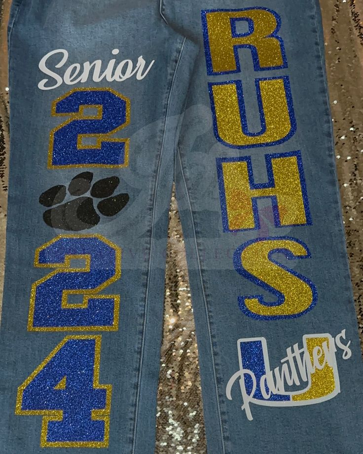 a pair of blue jeans with gold sequins and paw prints