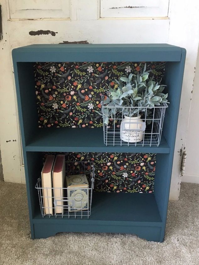 a blue book shelf with two baskets on it