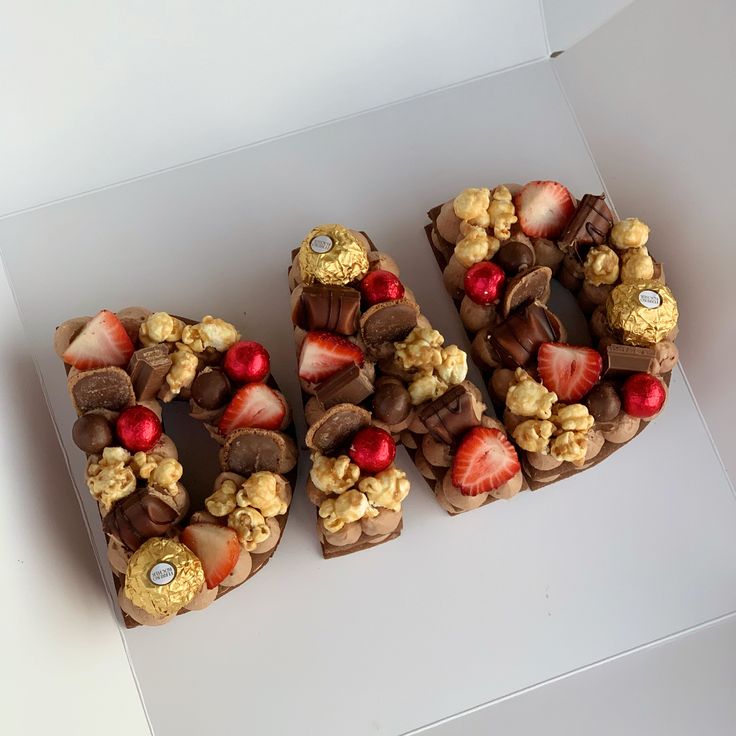 there are four pieces of chocolate with strawberries and nuts on them, arranged in the shape of the letter e