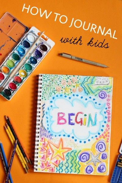 a notebook with the word begin written on it next to markers and paintbrushes