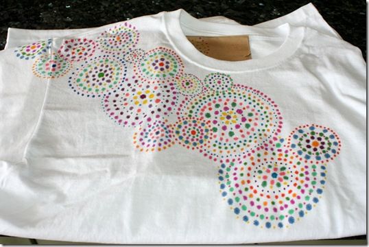 a white t - shirt with multicolored polka dots and a bear on it