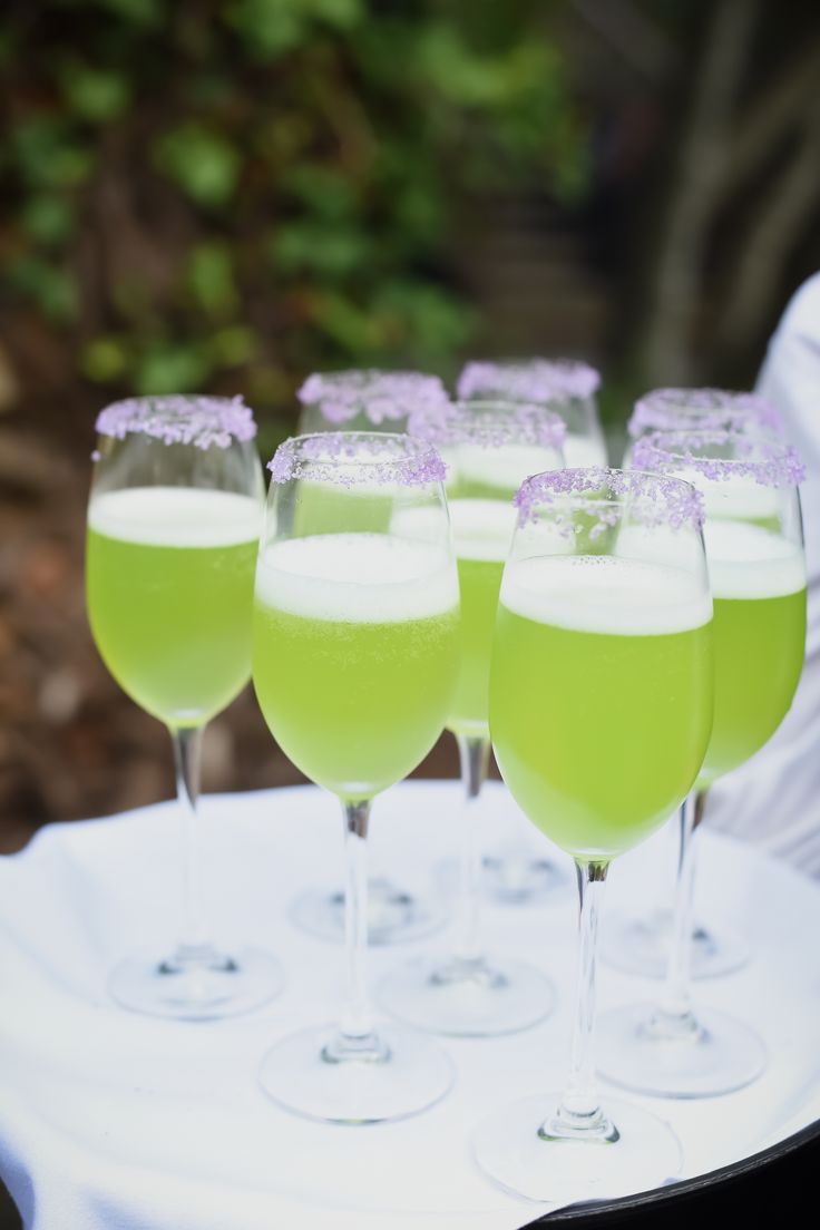 several glasses filled with green liquid sitting on top of a white tray next to each other