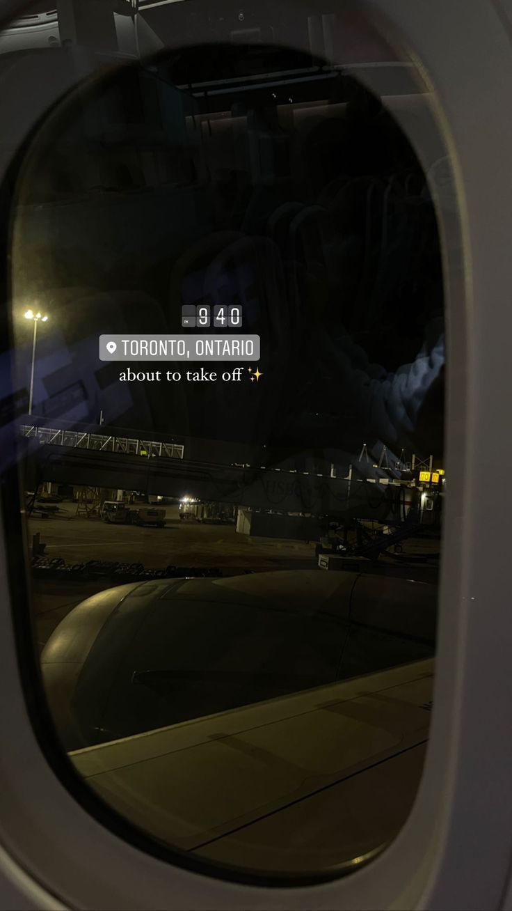 an airplane window with the view of a runway at night