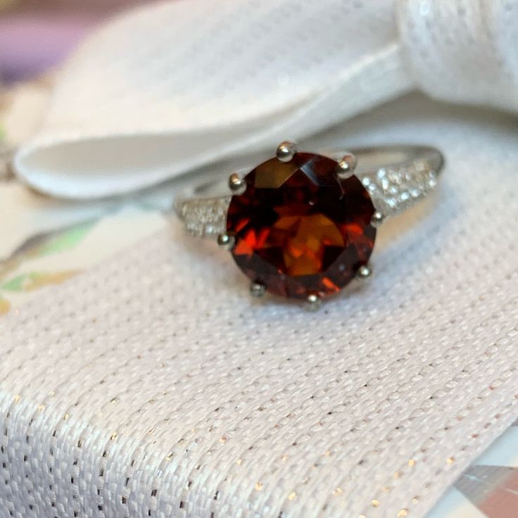 Brazilian Red Citrine Solitaire Ring With White Zircon* Accent Stones. Set In Platinum Over .925 Sterling Silver. Tgw 3.85 Carats. The Citrine Stone Is 10mm. Ring Is Size 7. Comes New In Box For Safekeeping And Gift Giving. Nwt *Zircon Is A Natural Gemstone Mined From The Earth And Not To Be Confused With The Man Made “Cz” Or Cubic Zirconia Red Sterling Silver Rings With Prong Setting, Red Sterling Silver Jewelry With Center Stone, Formal Sterling Silver Ruby Birthstone Ring, Classic Round Cut Sterling Silver Gemstones, Red Ruby Ring In Sterling Silver, Red Ruby Ring With Sterling Silver, Red Solitaire Sterling Silver Birthstone Ring, Red Sterling Silver Rings With Round Cut, Classic Red Gemstones With Center Stone