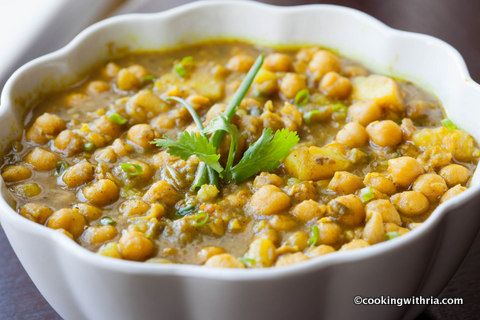 a white bowl filled with soup and garnished with green leafy garnish