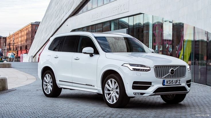 a white volvo suv parked in front of a building