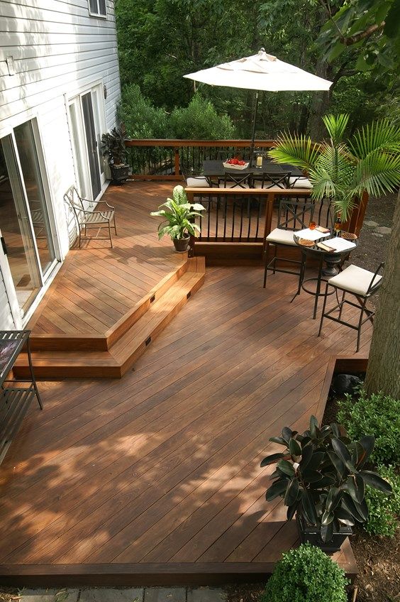 a wooden deck with chairs and an umbrella