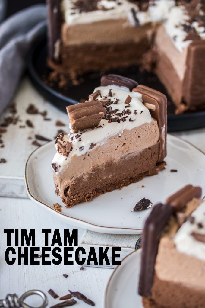 a slice of chocolate cheesecake on a plate with the rest of the cake in the background