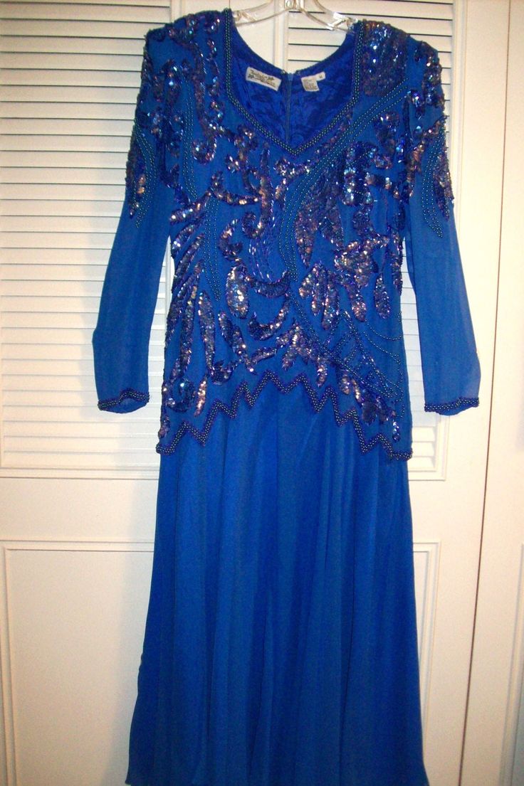 "Splendid evening in store! Royal blue dressy evening dress to end all. Bodice is sequins and bugle beads. All in tact. The skirt has an underskirt of royal blue satin. The over-skirt is silk chiffon. The dress is silk. See the last two pictures showing the back. The bust measures 40\", waist area 32\". Overall length 52\". Maxi length! This showpiece of a dress will be so happy to be waltzed in at a special occasion. It is absolutely PERFECT ! Look no further if this is your size ! No flaws of Embellished Blue Gown For Party Season, Blue Embellished Gown For Party Season, Holiday Sequined Mother Of The Bride Dress, Blue Sequin Evening Dress For Prom, Sequined Mother Of The Bride Dress For Evening Party, Blue Evening Mother Of The Bride Dress For Party, Blue Evening Mother Of The Bride Dress, Beaded Floor-length Party Dresses, Blue Festive Evening Dress For Prom