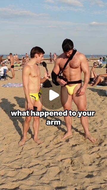 two men in swimsuits standing on the beach