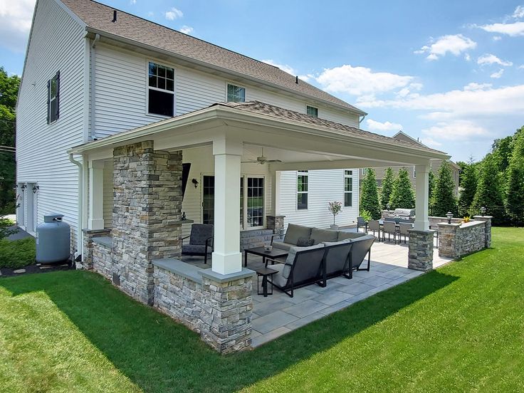 an outdoor patio with chairs and grill in the back yard