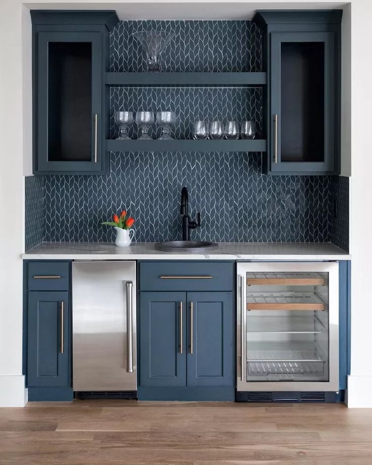 a kitchen with blue cabinets and stainless steel appliances