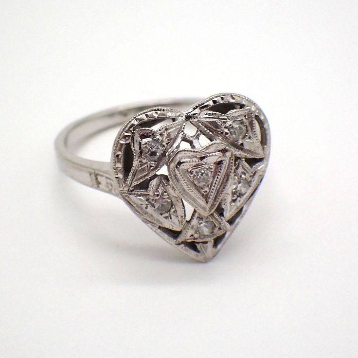 Edwardian style 14k (.585) white gold ring with a heart-shaped front, accented with single cut Diamonds - approx. 0.06ctw, I1 clarity, color I-J. This charming ring is a size 6, 18.5 mm at the widest and weighs 3.4 grams. EA3286 Heart Cut Diamond Ring With Rose Cut For Promise, Heart Cut Rose Cut Diamond White Rings, Formal Heart-shaped Diamond Ring, Elegant Heart Cut Diamond Ring With Rose Cut Diamonds, Elegant Heart Cut Rose Diamond Ring, Heart Cut Diamond Rings With Single Cut Diamonds, Hallmarked Heart-shaped Diamond Ring, Fine Jewelry Heart Cut Diamond Ring, White Gold Rings With Diamond Accents For Valentine's Day