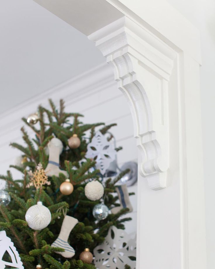 a small christmas tree with stockings hanging from it's sides and ornaments on the top