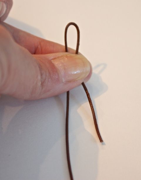 a hand holding a string that is brown