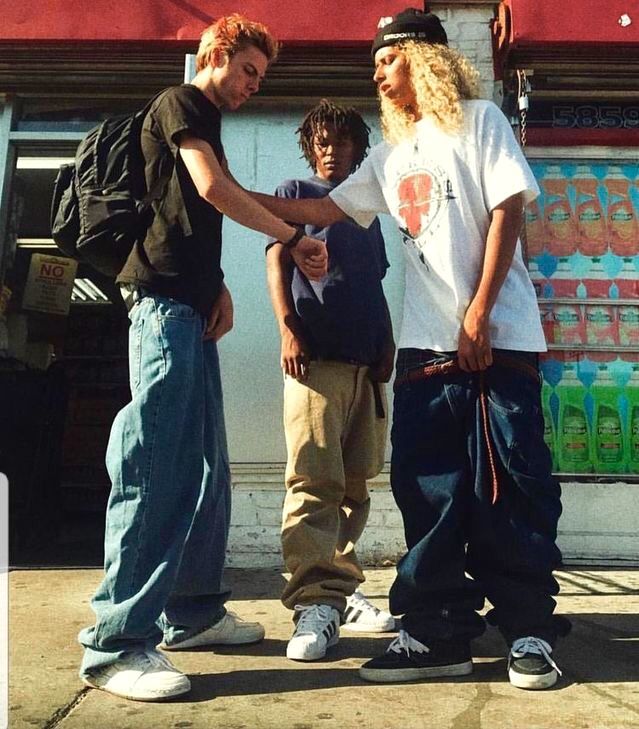 three young men standing next to each other in front of a store