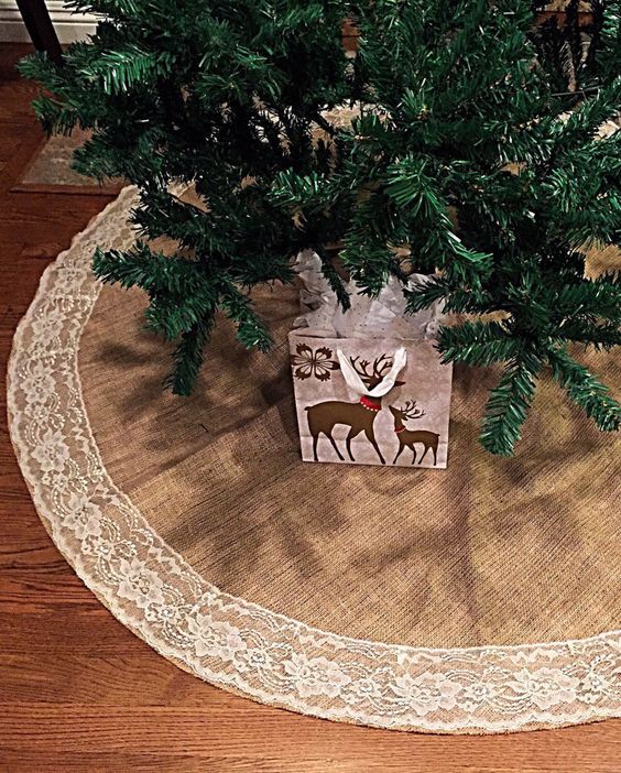 a small christmas tree on top of a wooden table next to a white doily