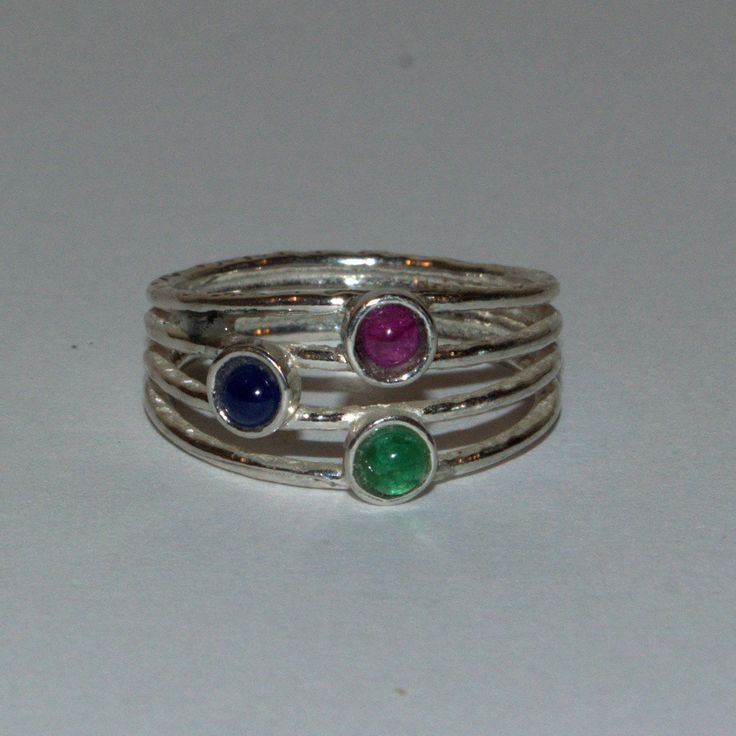 Ruby Sapphire and Emerald silver ring Pretty 925 stamped textured silver ring featuring a Ruby, a Sapphire and an Emerald.     * 1 x 3mm round Ruby cabochon     * 1 x 3mm round Sapphire cabochon     * 1 x 3mm round Emerald cabachon     * 925 Sterling silver     * UK ring size: N/US ring size:  6 3/4 It was believed a Ruby would bring the wearer, health, wealth, wisdom, and success in love, a Sapphire would bring gifts of joy, inner peace and beauty, and an Emerald would bring wit, eloquence, and Emerald Silver Ring, Silver Celtic Jewelry, Silver Celtic Rings, November Birthstone Jewelry, Solid Silver Bracelets, February Birthstone Jewelry, December Birthstone Jewelry, January Birthstone Jewelry, Sapphire Cabochon