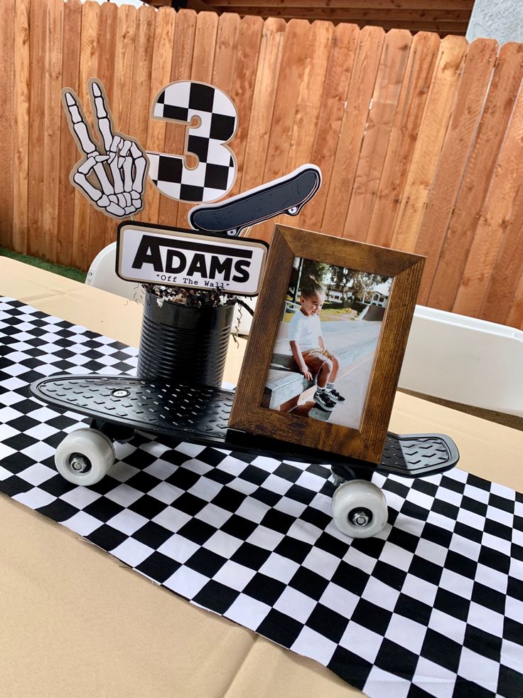 a skateboard is sitting on top of a table with a sign and photo frame