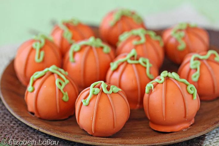 small pumpkin candies on a plate with green sprinkles