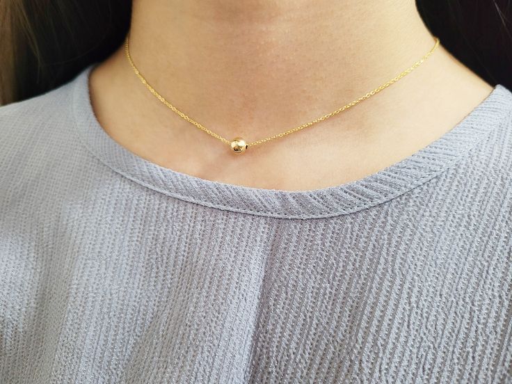 Add a touch of elegance with this simple delicate necklace featuring a dainty Gold Filled Ball floating on a chain. This simple floating necklace is the perfect finishing piece to any outfit. Wear it alone or layered with other necklaces. A great everyday necklace to add to your collection. The gold ball on this necklace is mobile and moves around the chain, turning it into the perfect dainty fidget necklace. Makes a great gift to add to any gemstone lover's collection. Perfect to gift for Chris Elegant Layered Necklace With Delicate Chain And Round Pendant, Elegant Layered Necklace With Round Pendant, Minimalist Station Necklace With Satellite Chain As A Gift, Minimalist Station Necklace With Satellite Chain For Gift, Dainty Station Necklace With Delicate Chain As Gift, Dainty Station Necklace With Delicate Chain, Simple Necklace With Delicate Chain For Layering, Simple Everyday Necklace With Delicate Chain, Minimalist Layered Necklace With Adjustable Chain