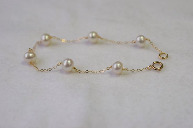 The size of the freshwater cultured pearls are 6.5x6mm. The pearls are slightly off round, white in color with high luster. Each bracelet comes with 6 pearls and is linked with 14K yellow gold chain. You will received pearls very similar to the ones photographed. If you are looking for something delicate and girly this is for you! If your length is not listed, please message me. Please keep in mind that this item is unique and handmade. We will ship out the goods once we have received payment. F Delicate Pearl Drop Bracelet For Formal Occasions, Elegant White Pearl Bracelet In 14k Gold, Delicate Formal Pearl Bracelet, Gold Akoya Pearl Bracelet For Wedding, Dainty Pearl Bracelet With Round Beads For Formal Occasions, Dainty Pearl Bracelet For Formal Occasions, Formal Akoya Pearl Bracelet In Gold Color, Formal Gold Akoya Pearl Bracelet, Formal Yellow Gold Pearl Bracelet With Pearl Drop