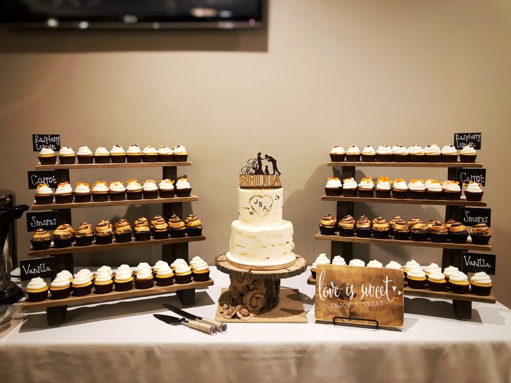 a table topped with lots of cupcakes next to a sign that says love you