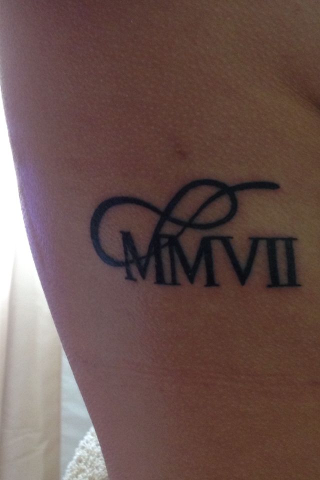 a woman's arm with the word mmvi in black ink on her left side