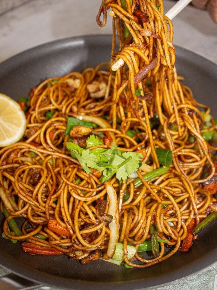 someone is eating noodles with chopsticks in a pan