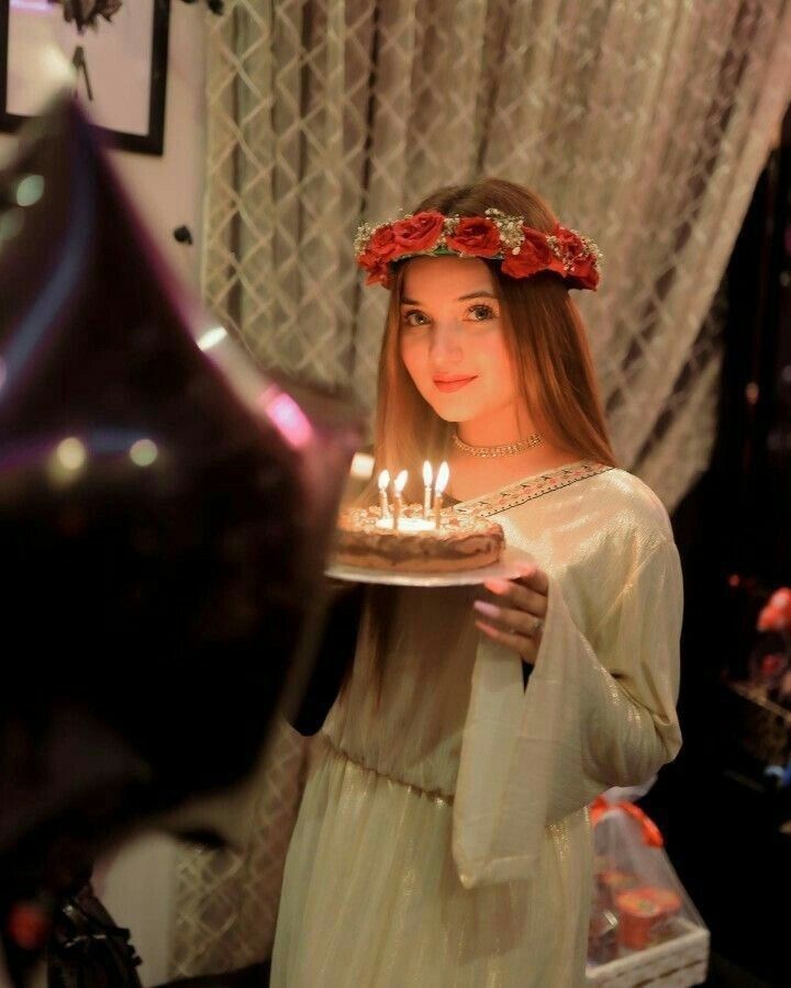 a woman holding a cake with candles on it